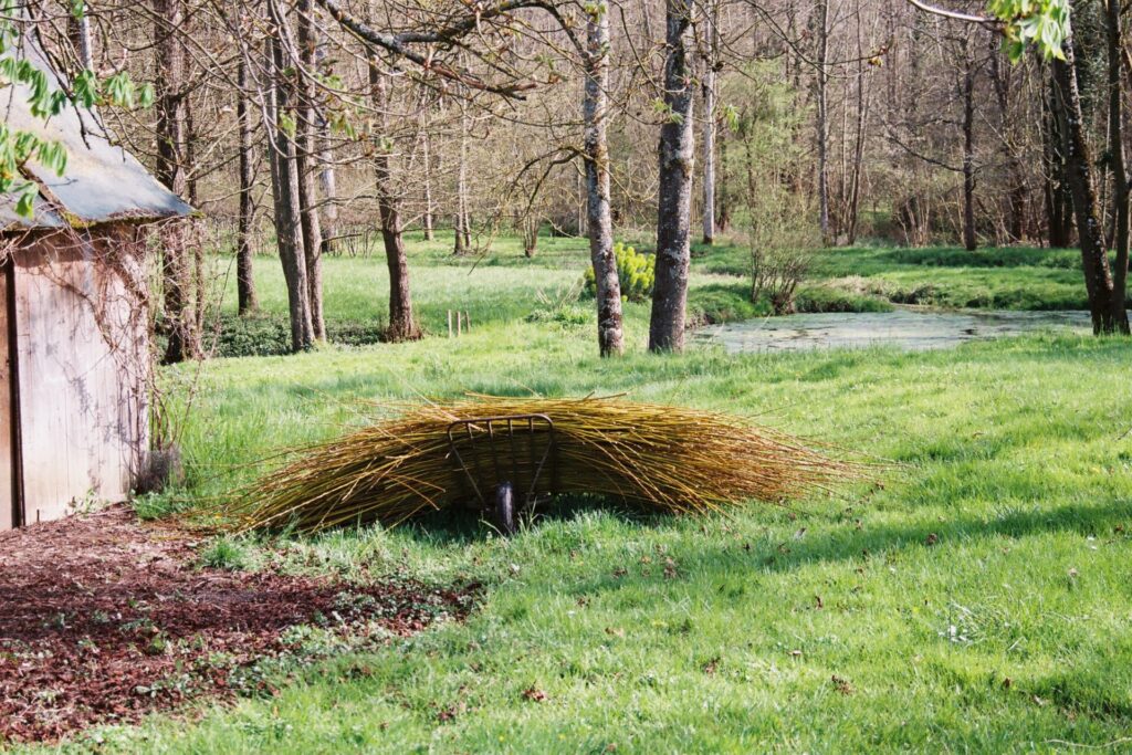 Les osiers sur une brouette devant le petit étang du musée de Laduz